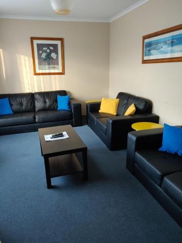 a living room with couches and a coffee table at Summers Rest Units in Port Campbell