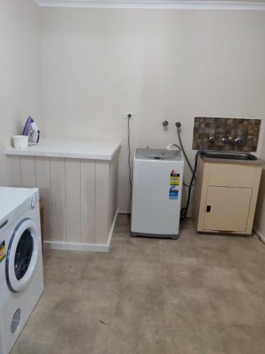 a kitchen with a washer and a washing machine in it at Summers Rest Units in Port Campbell