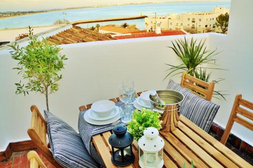a table on a balcony with a view of the ocean at Baluarte da Vila Apartments in Lagos