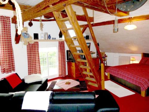 sala de estar con cama y escalera de madera en Mühlenteich in der Oldenstädter Wassermühle, en Uelzen