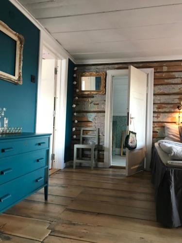 a bedroom with blue walls and a wooden floor at Pensionatet in Piteå