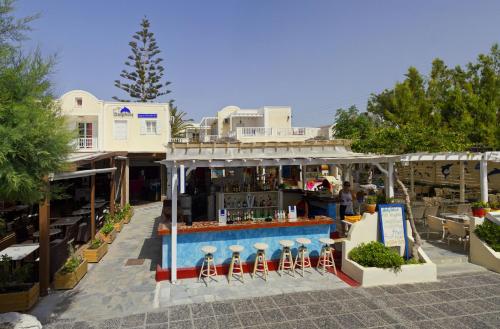 a restaurant with a bar in front of a building at Dolphins Apartments in Kamari