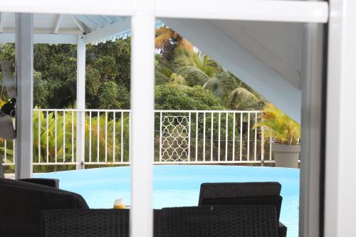 uma vista para uma piscina a partir de um alpendre coberto em Lauraym2 em Baie-Mahault