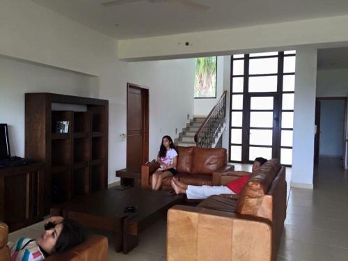 un grupo de personas sentadas en una sala de estar en Playa Limoncito Hills Fraccionamiento Vacacional Villas de 2 & 3 Recamaras con Alberca Privada o Alberca Compartida, en Limoncito Hill