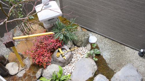 a garden with rocks and plants and a fence at Nishioji FUKURO in Kyoto