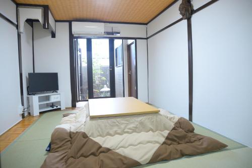 a room with a bed and a flat screen tv at Nishioji FUKURO in Kyoto