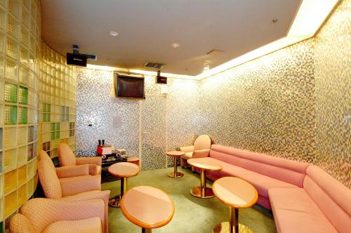 a waiting room with a pink couch and tables at Suimeikan in Gero