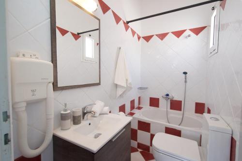 a bathroom with a sink and a toilet and a mirror at Syriti Studios in Skala Kefalonias