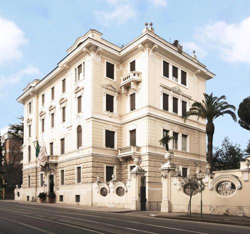 un edificio blanco con una palmera delante en Aldrovandi Residence City Suites en Roma