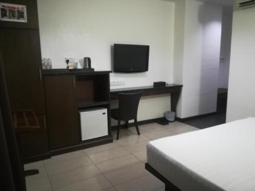 a hotel room with a desk and a television at Crystal Lodge in Kota Bharu