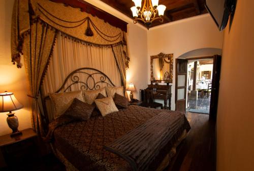 a bedroom with a bed and a chandelier at Hotel La Catedral in Antigua Guatemala