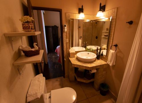 a bathroom with a sink and a toilet and a mirror at Hotel La Catedral in Antigua Guatemala