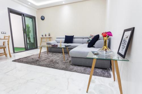 un soggiorno con divano e 2 tavoli di Miramar Residence Beach a Mohammedia