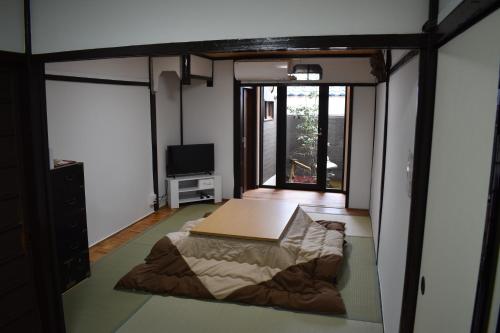 a bedroom with a bed in a room with a window at Nishioji FUKURO in Kyoto
