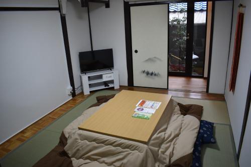 a living room with a bed and a table at Nishioji FUKURO in Kyoto