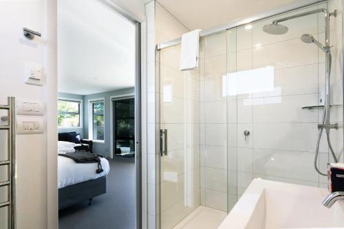 a bathroom with a shower and a sink and a bed at High Country Retreat - Lake Tekapo in Lake Tekapo