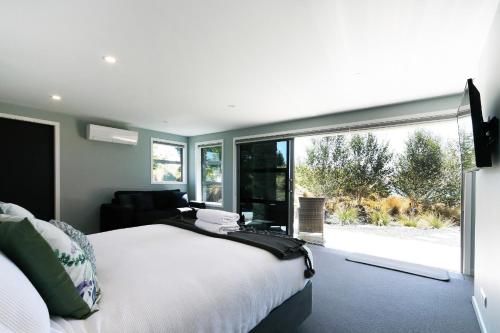 een slaapkamer met een bed en een groot raam bij High Country Retreat - Lake Tekapo in Lake Tekapo