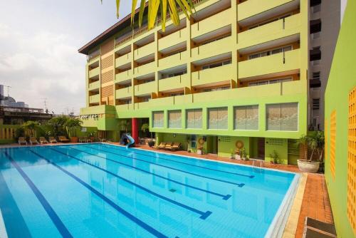 a large swimming pool in front of a building at The Aiyapura Bangkok in Bangkok