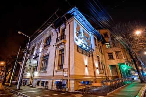 un bâtiment avec une horloge sur son côté la nuit dans l'établissement Hotel Carol, à Constanţa