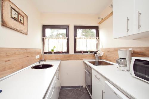 a white kitchen with a sink and a window at Ferienhaus Seestern am Steinhuder Meer, 5 Schlafzimmer in Steinhude