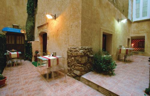 a patio with tables and chairs in a building at Donnaciccina Accomodation in Tropea