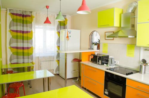 a kitchen with yellow and green cabinets at Millenium in Omsk