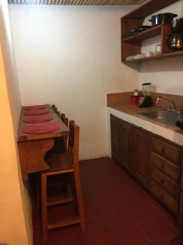 a kitchen with a counter and a sink and a table at Loft con excelente ubicación en Valle de Bravo in Valle de Bravo