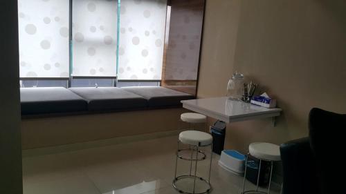 a room with a bed and stools and a window at The Sixth Room in Yogyakarta