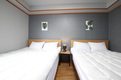 two beds sitting next to each other in a bedroom at Gyeongju Bee House in Gyeongju