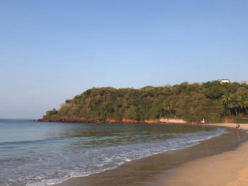 a sandy beach with a hill in the background at All Seasons Guest House in Vasco Da Gama