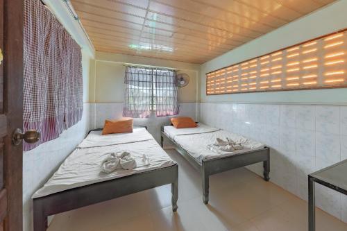 a room with two beds and a window at Homestay Chreav in Siem Reap