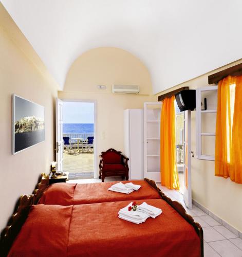 a bedroom with a bed with a view of the ocean at Dolphins Apartments in Kamari