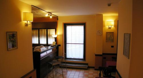 um quarto com um corredor com uma janela e paredes amarelas em Hotel Forum em Rozzano