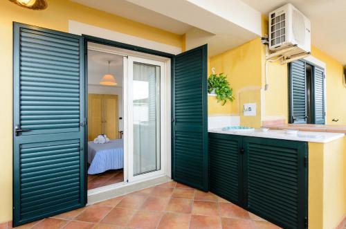 a bathroom with green sliding doors and a sink at Le Tartarughe Aparthotel in Letojanni