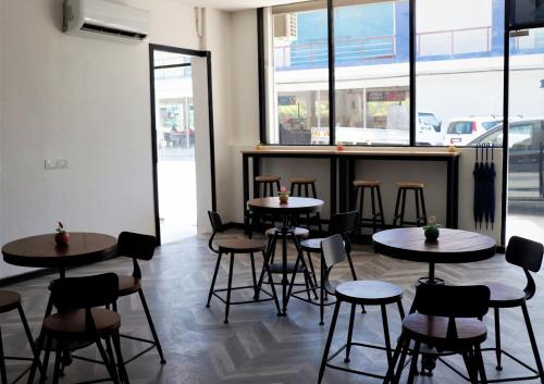 a restaurant with tables and chairs and a bar at Halo Hotel in Semporna