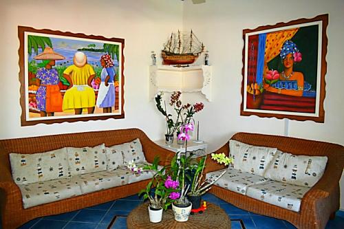 a living room with two couches and paintings on the wall at A La Dolce Vita Beachfront Hotels, Las Terrenas, Samana in Las Terrenas