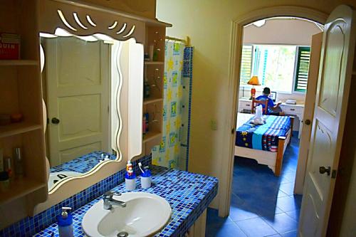 a bathroom with a sink and a mirror and a bedroom at A La Dolce Vita Beachfront Hotels, Las Terrenas, Samana in Las Terrenas