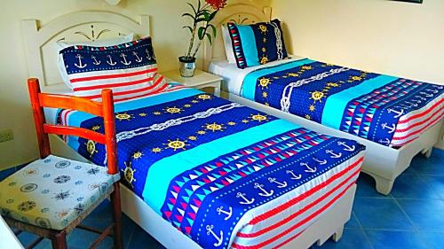 a room with two beds and a chair at A La Dolce Vita Beachfront Hotels, Las Terrenas, Samana in Las Terrenas