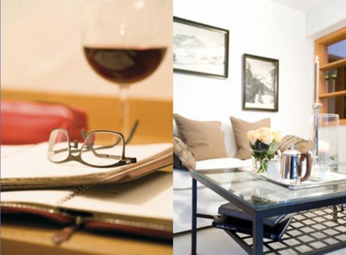 a glass of wine and a table with a glass of wine at Gästehaus Daheim in Riezlern
