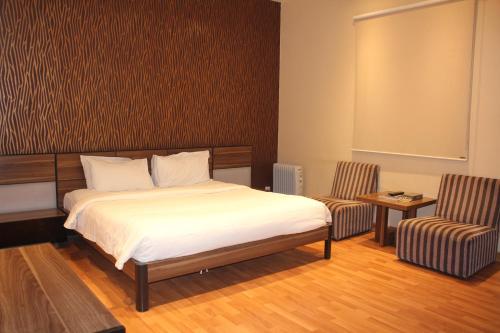 a bedroom with a bed and two chairs at Rafa Homes Al Izdihar 1 in Riyadh
