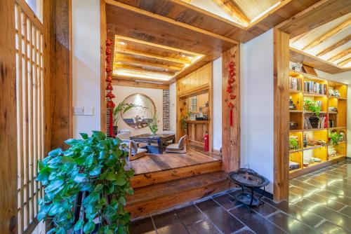 a hallway of a house with a large green plant at Zhangjiajie National Park Yuelu Homestay in Zhangjiajie