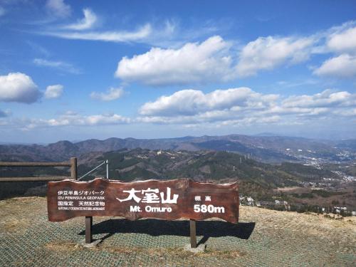 a sign sitting on top of a mountain at Izu Hokkawa Seaside Guesthouse 伊豆北川の家 in Higashiizu