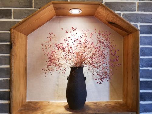 a vase sitting on a table with a painting of flowers at Zhangjiajie National Park Yuelu Homestay in Zhangjiajie