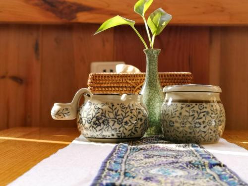 a table with two vases and a plant on it at Zhangjiajie National Park Yuelu Homestay in Zhangjiajie