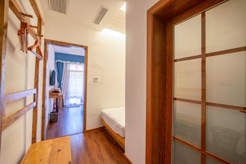 a room with a bed and a glass door at Zhangjiajie National Park Yuelu Homestay in Zhangjiajie