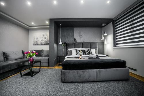 - une chambre avec un grand lit et un canapé dans l'établissement Sinergija, à Belgrade