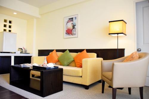 a living room with a couch and a table at The Color Living Hotel in Bangna
