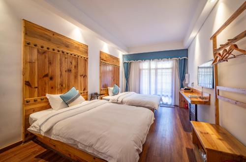 two beds in a room with blue walls and wooden floors at Zhangjiajie National Park Yuelu Homestay in Zhangjiajie