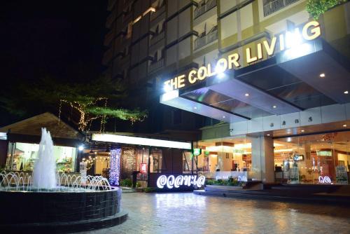 a fountain in front of a store at night at The Color Living Hotel in Bangna