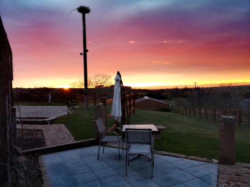 a patio with a table and an umbrella and a sunset at Au Bunker 67 in Rott